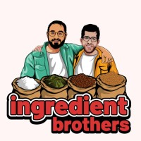 Two men standing behind 4 sacks of food.