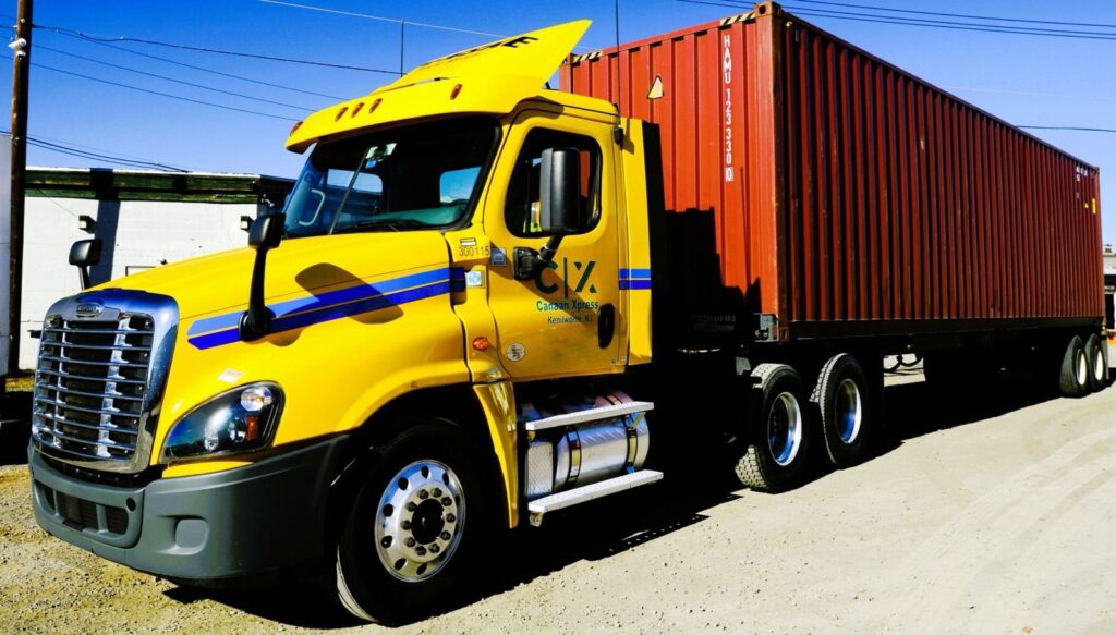 A yellow truck with a red container.